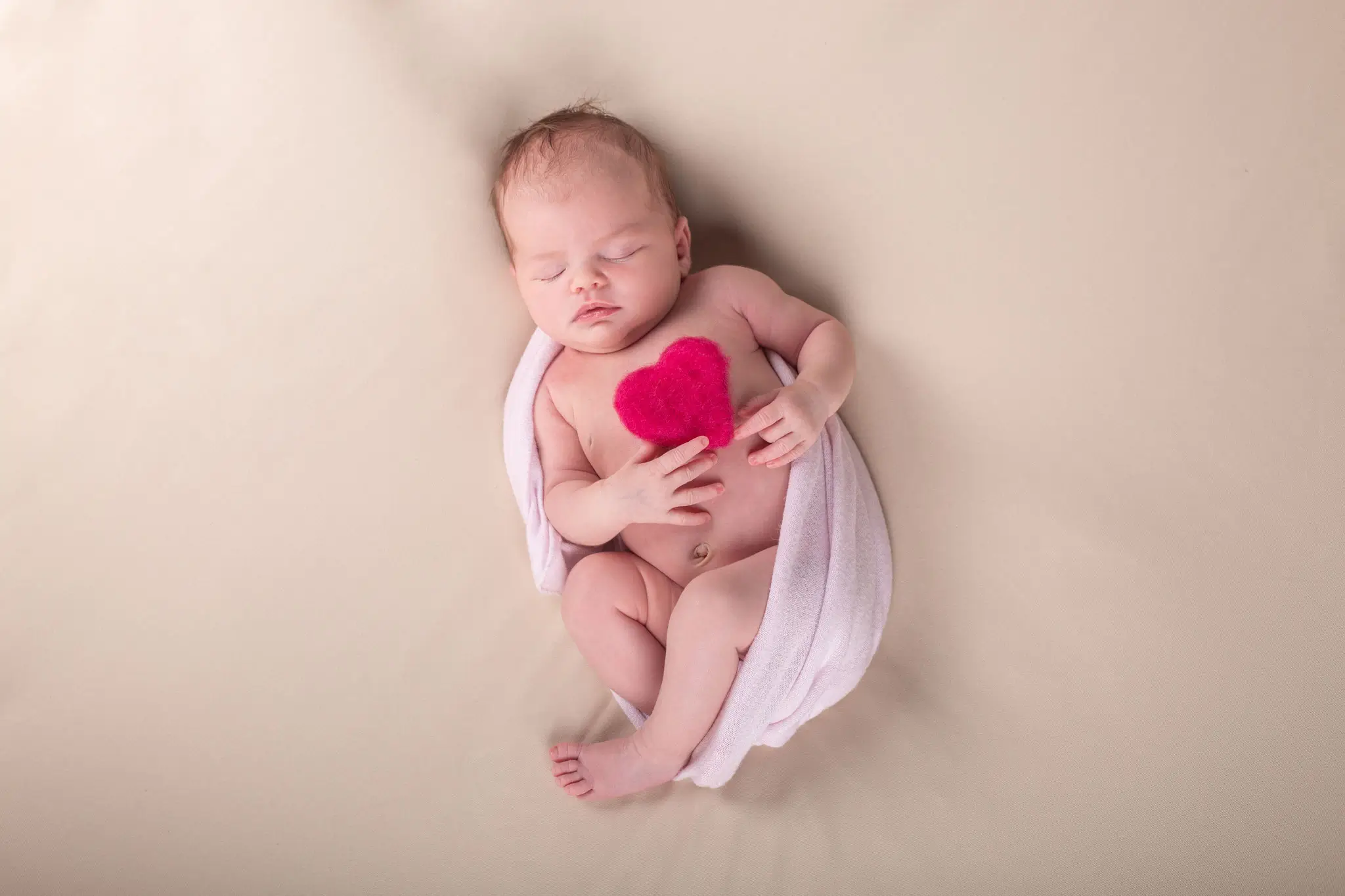 Photo bébé endormi dans un wrap, avec un cœur par la photographe Julie Kirtz