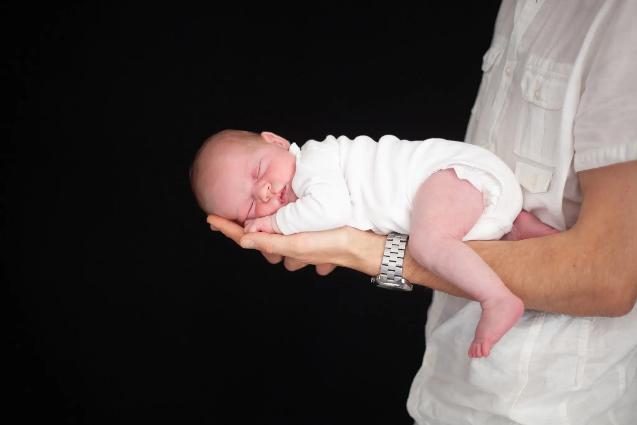 Photo bébé endormi dans les bras de son papa par la photographe Julie Kirtz