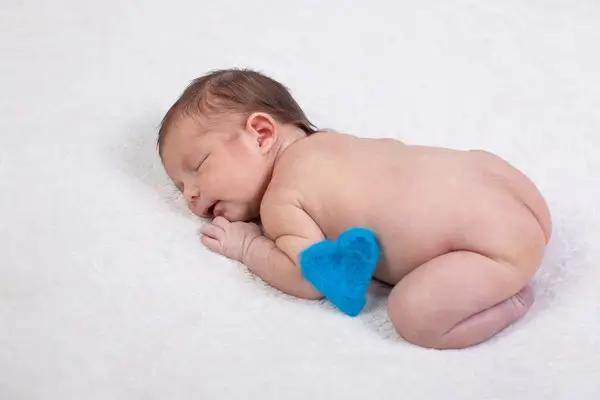 Photo bébé garçon endormi sur le ventre avec un cœur bleu par la photographe Julie Kirtz
