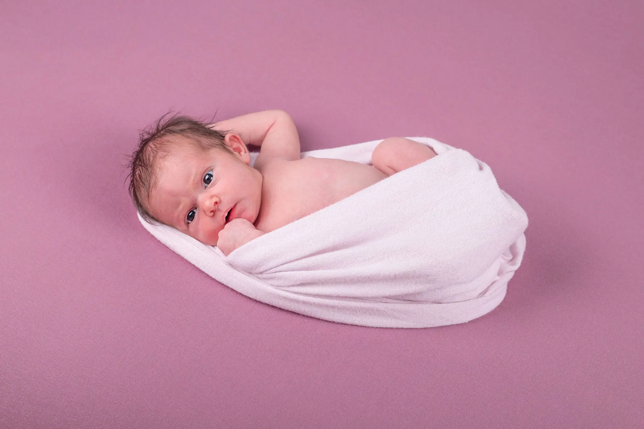 Séance photo bébé emmailloté dans un wrap par la photographe Julie Kirtz