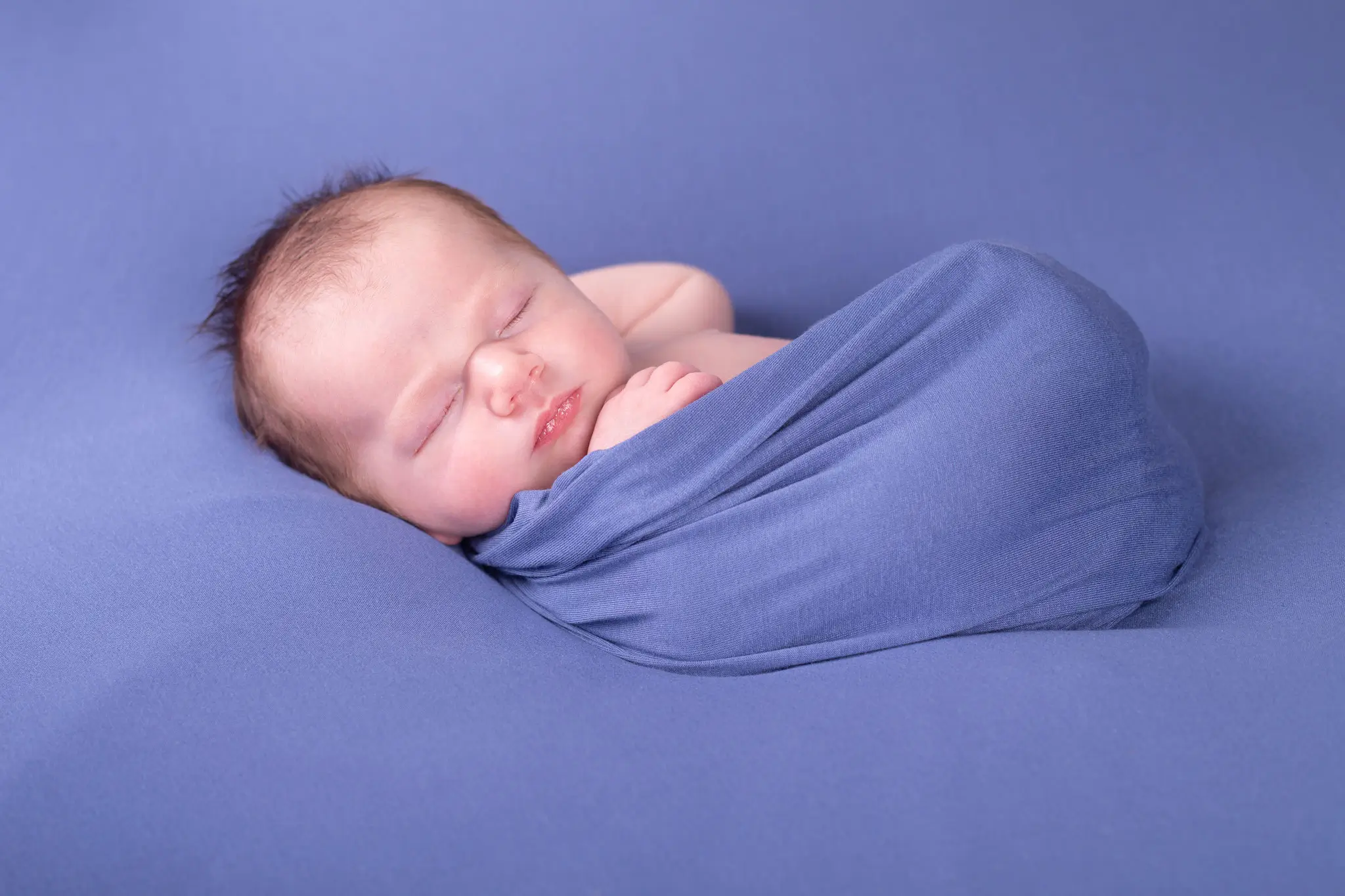 Séance photo bébé emmailloté dans un wrap par la photographe Julie Kirtz
