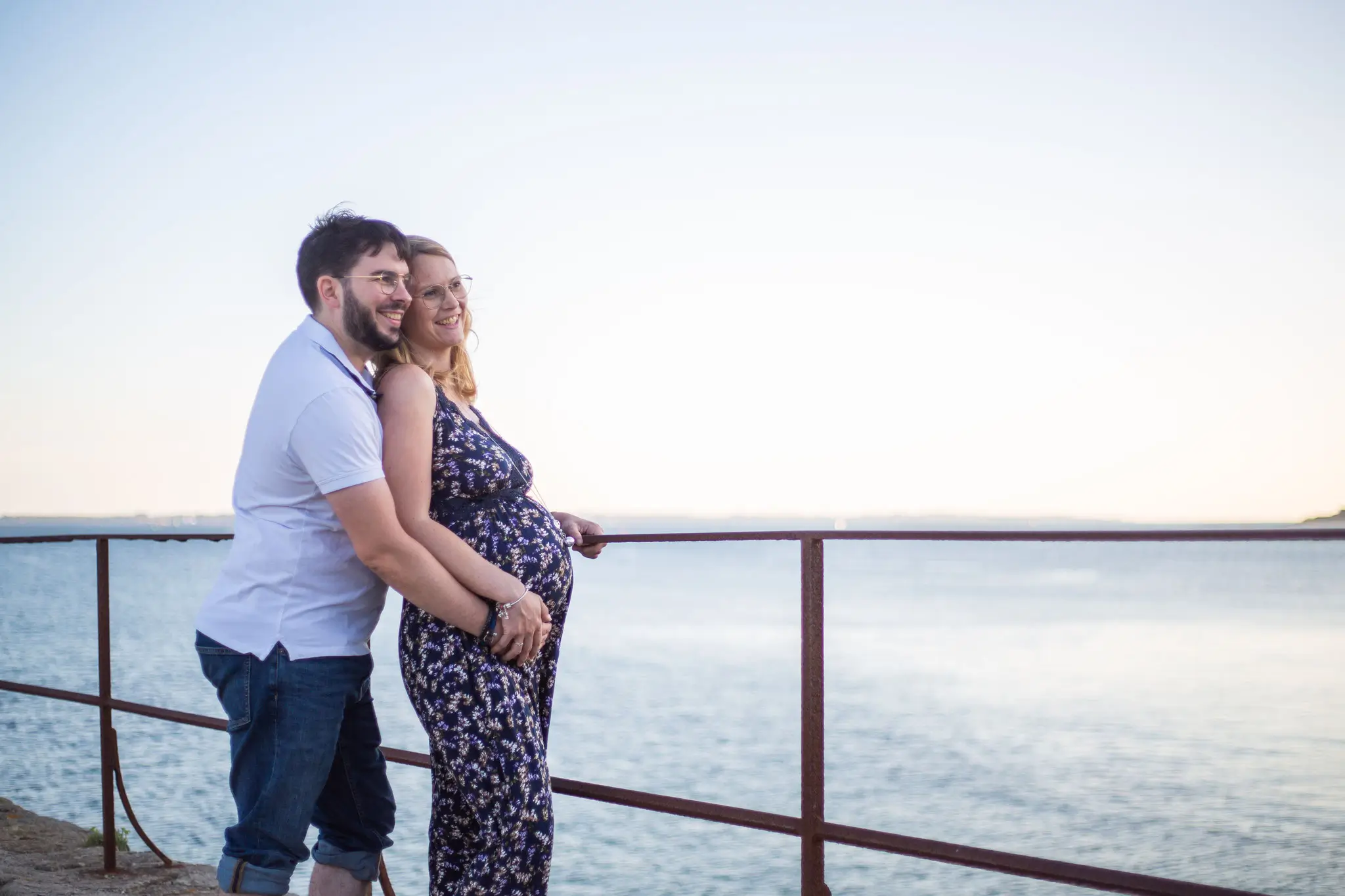 Photo de couple femme enceinte face à la mer