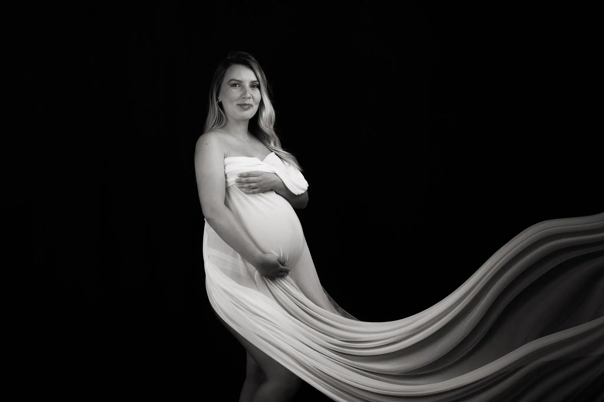 Photo de femme enceinte dans un voile blanc en noir et blanc