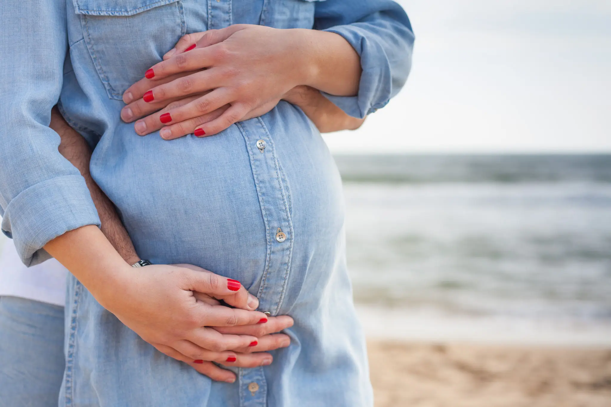 Photo de femme enceinte et future papa à la plage 