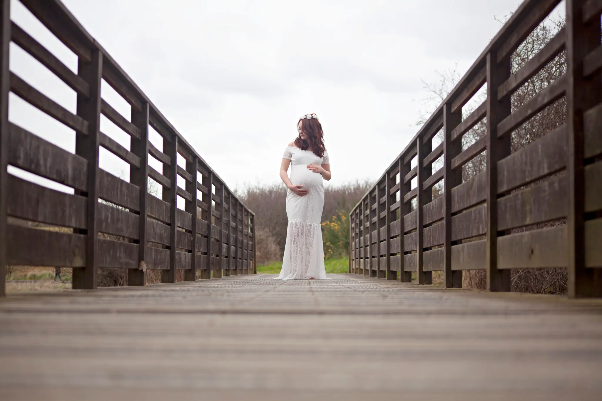 Photo de femme enceinte en robe blanche sur un pont