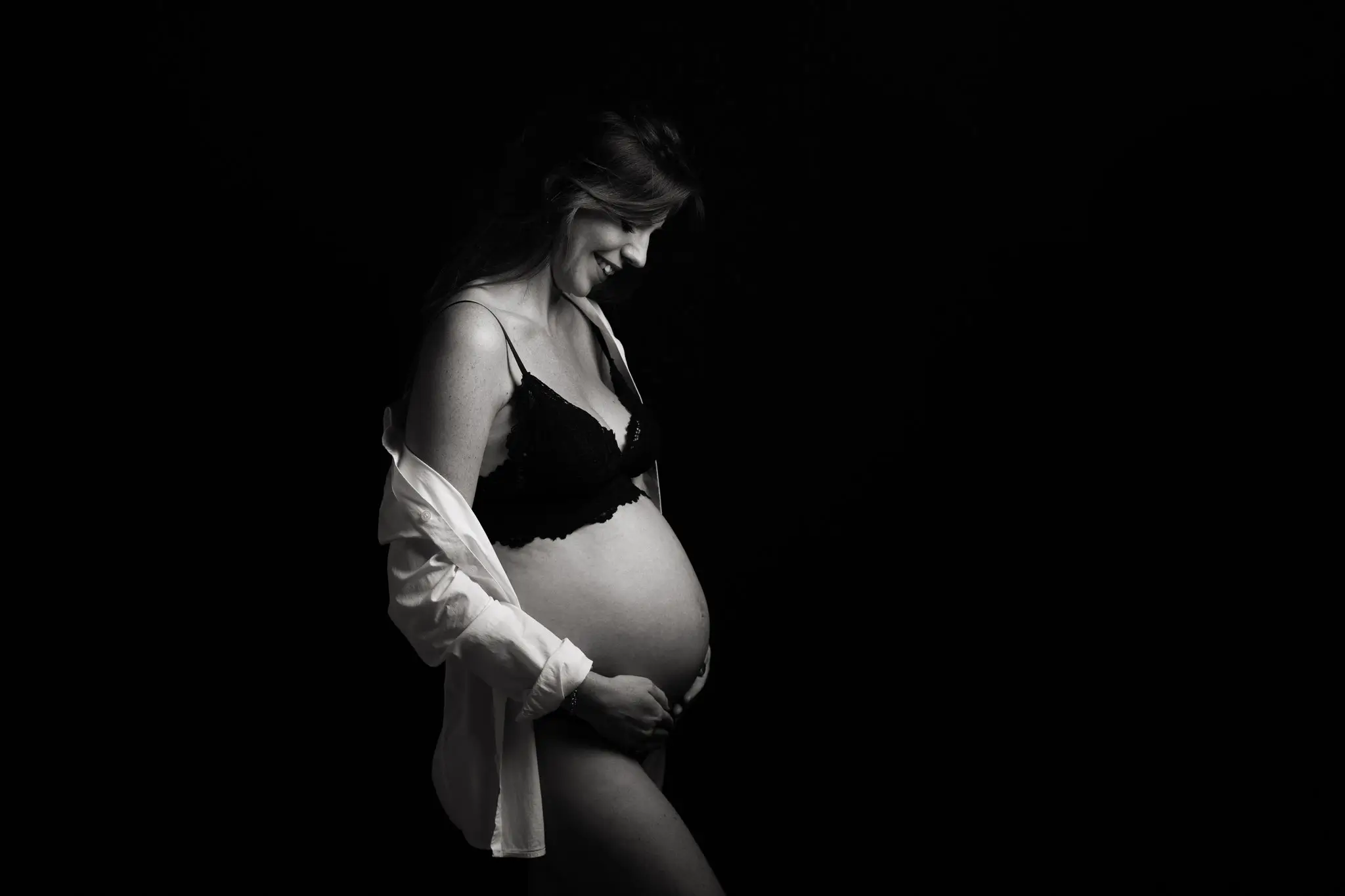 Femme enceinte qui sourit en noir et blanc