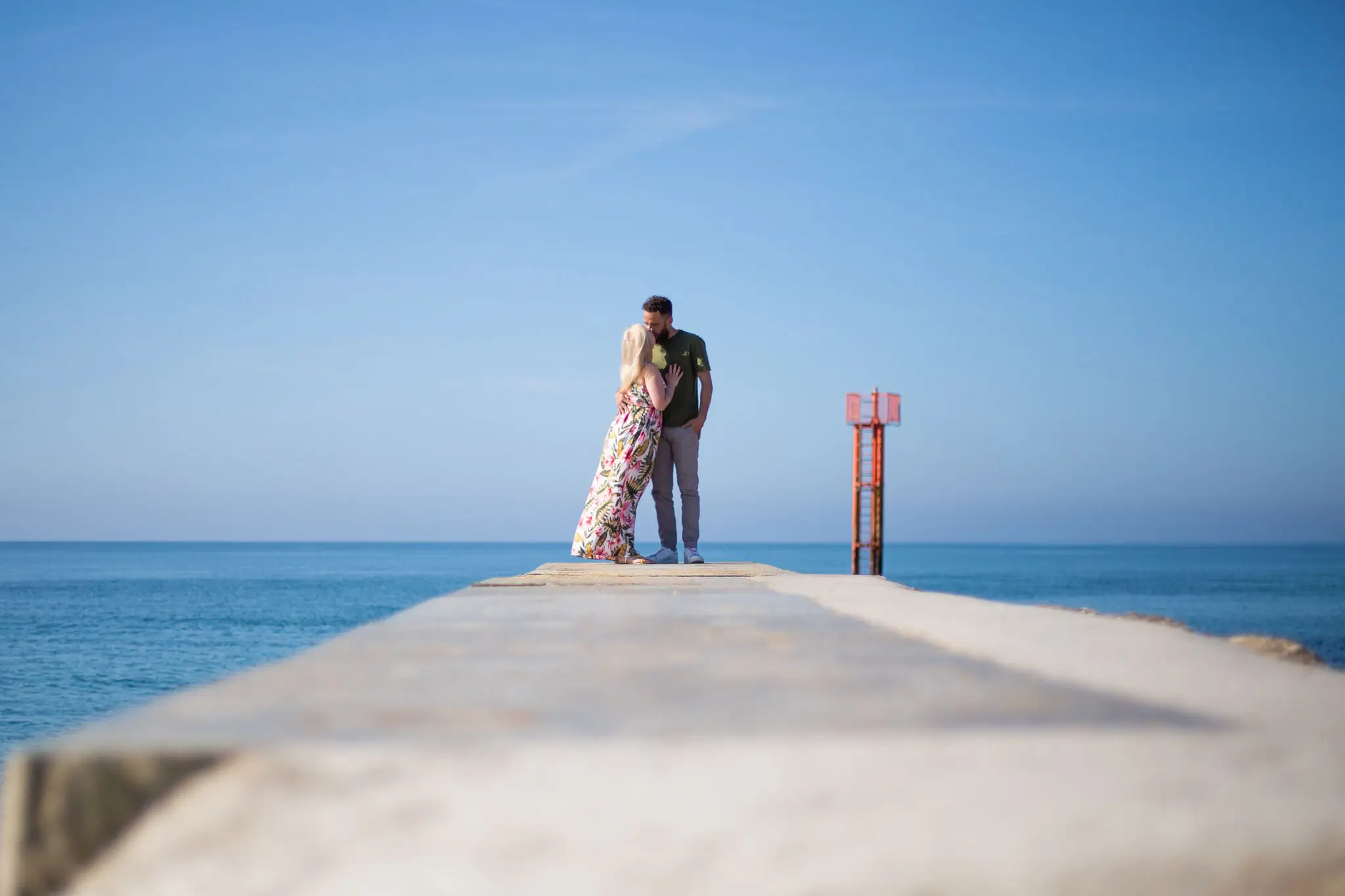 Photo de couple qui s'embrasse face à la mer