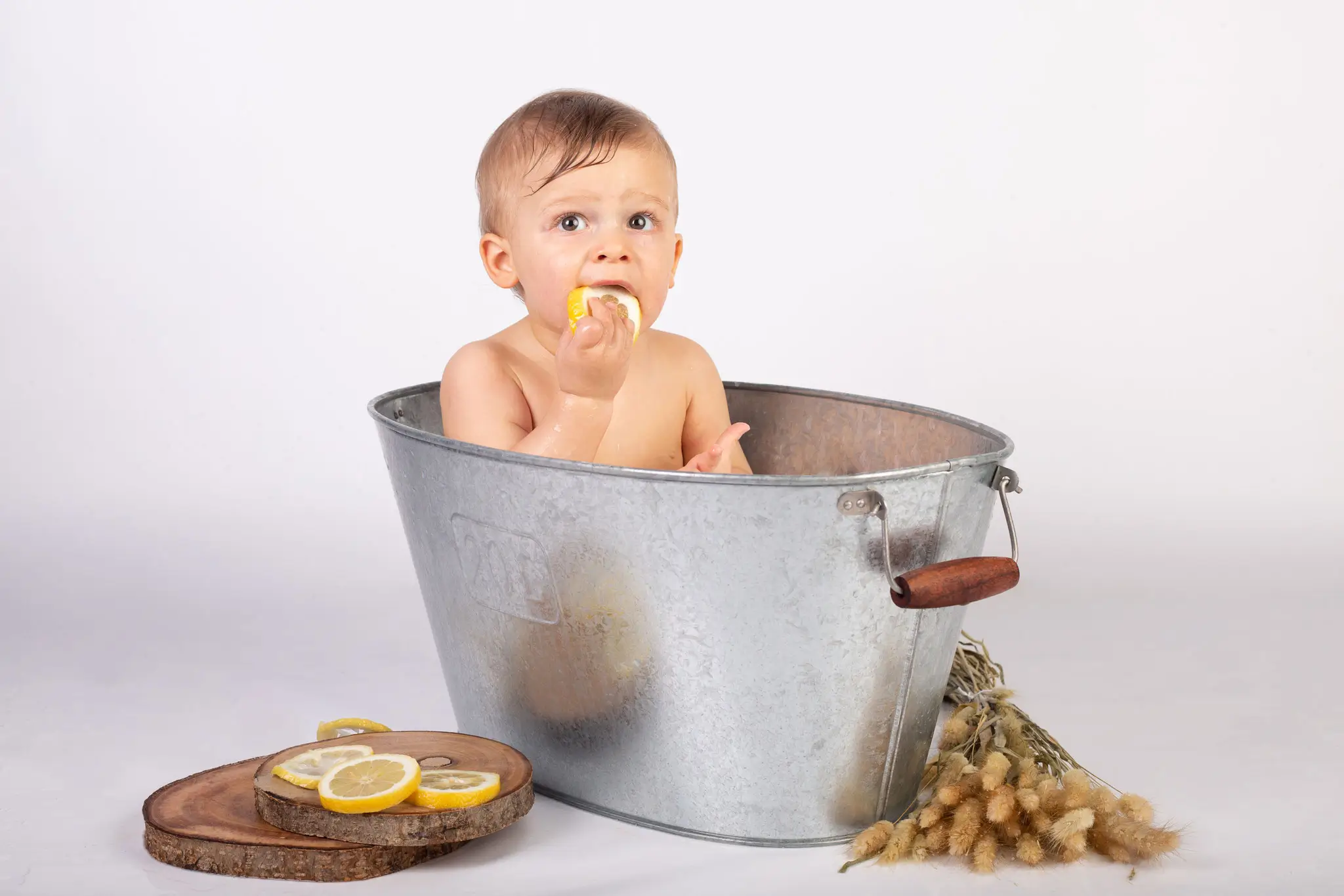 Séance photo bébé bain de lait qui croque un citron