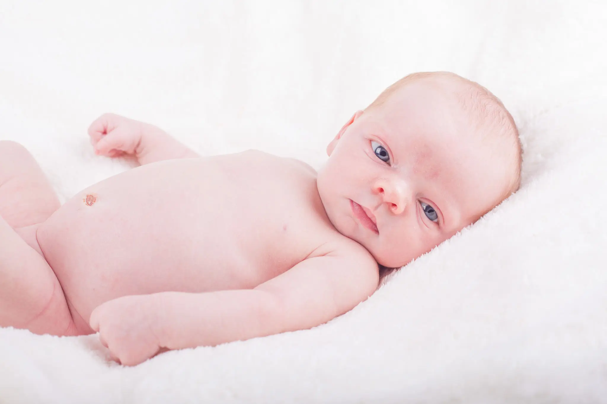 Séance photo bébé sur le dos avec les yeux grand ouvert par la photographe Julie Kirtz