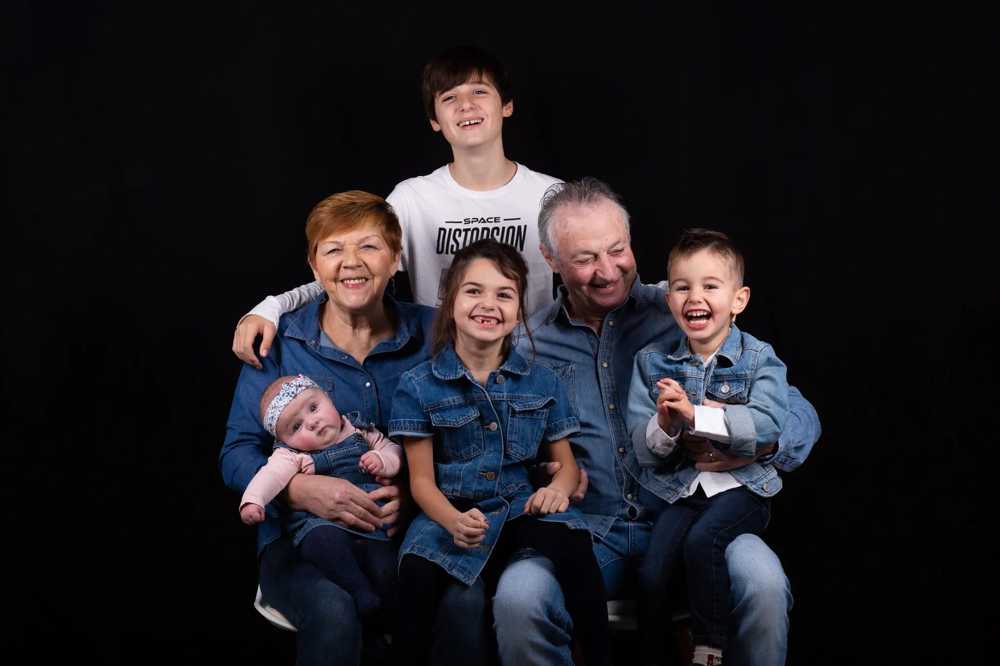 Séance photo grands-parents et petits enfants en studio sur fond noir 